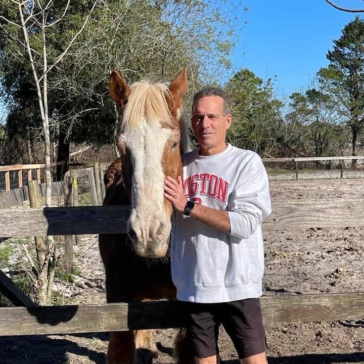 David Waronker, Director and Owner, pictured with an adopted horse on the farm